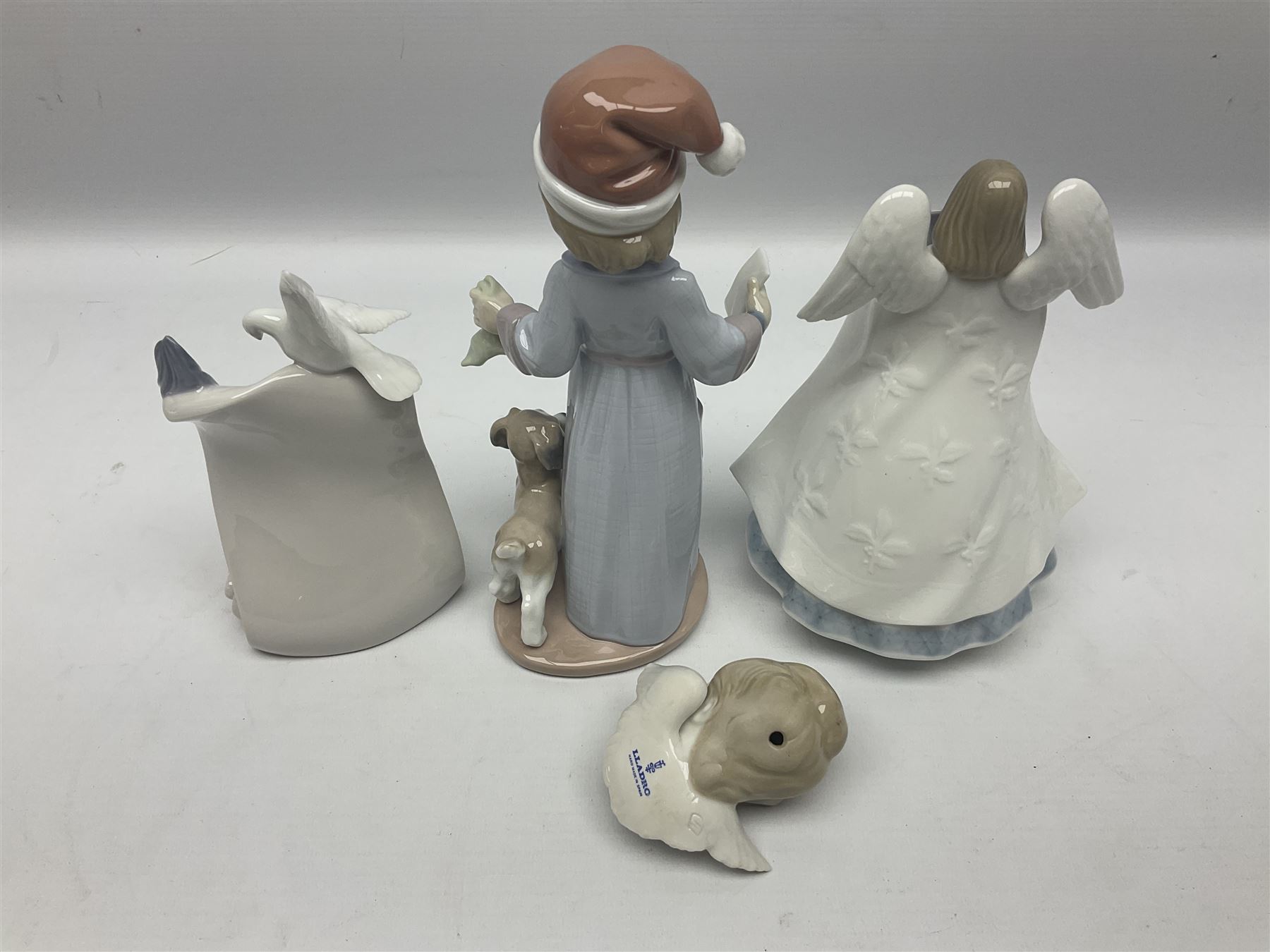 Three Lladro figures, comprising Dear Santa no 6166, Angelic Melody 1993 no 5963 and Seraphs Head no2 no 4885, together with Lladro plaque Love Brings Us Together no 7677, all with original boxes, largest example H18cm