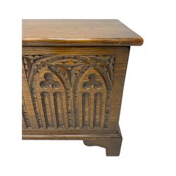 Mid-20th century oak blanket box, hinged lid over front carved with Gothic tracery work and flower heads, on bracket feet