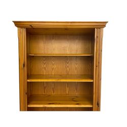 Traditional pine open bookcase on cupboard, fitted with three adjustable shelves over a double cupboard with panelled doors