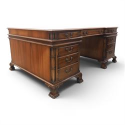 George III style large mahogany reverse breakfront partners desk, red tooled leather writing surfaces crossbanded and moulded edges, flanked by ring-turned cluster columns three frieze drawers with brass swan neck handles, raised on large pedestals with faux drawer fronted cupboard and three graduated drawers, supported on carved ogee feet decorated with C-scrolled and acanthus leaves