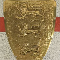 Five wall hangings, modelled as shields, decorated to the centre in relief with three lions 