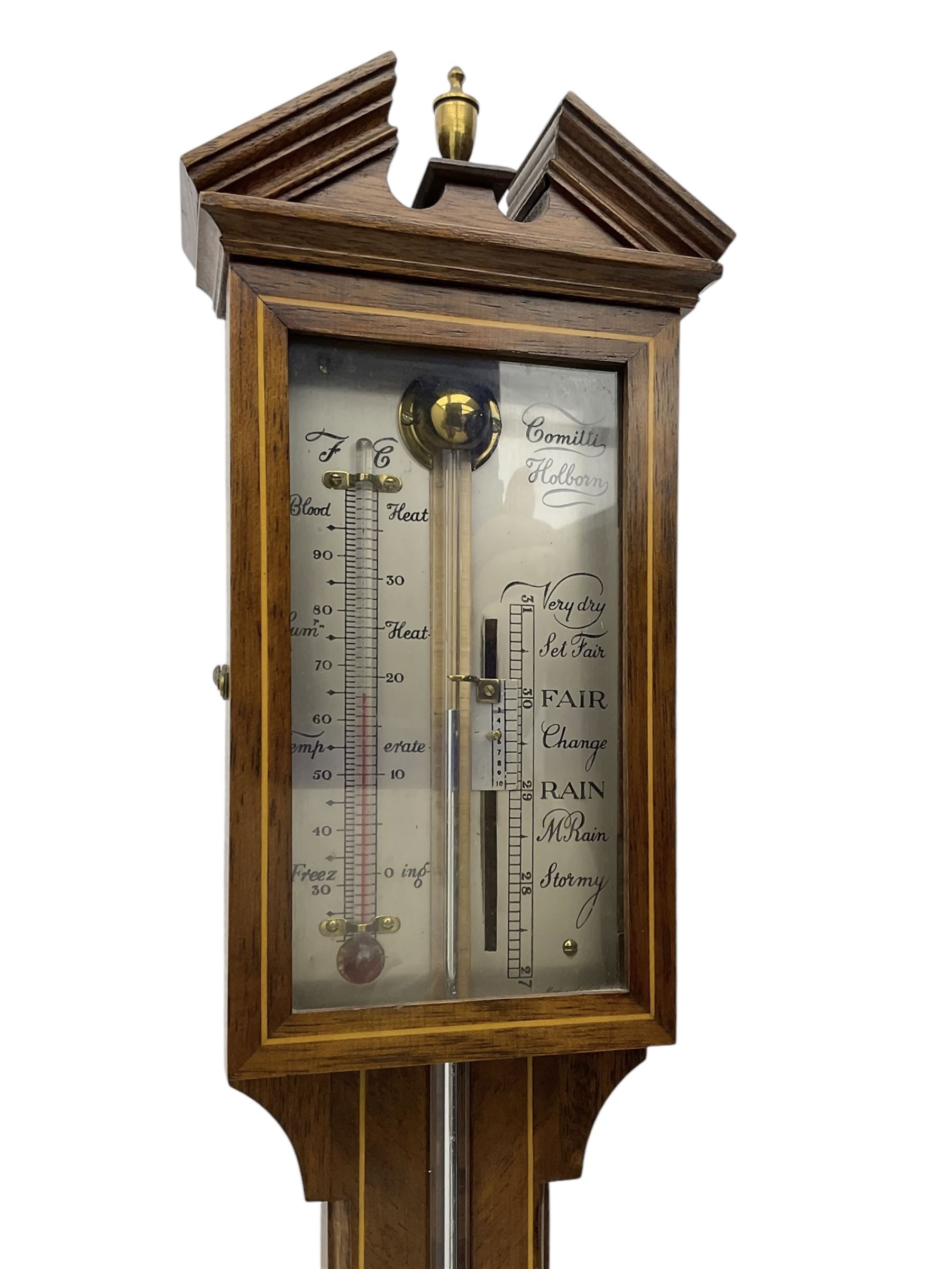 Comitti-20th century mercury stick barometer in an 18th century style mahogany case with satinwood stringing, with a broken pediment, brass finial and round base, silvered register with recording vernier, weather predictions and a centigrade/Fahrenheit spirit thermometer enclosed within a glazed door, visible tube with a bulb cistern and turned mahogany cover.
Mercury clean and present with no air locks.