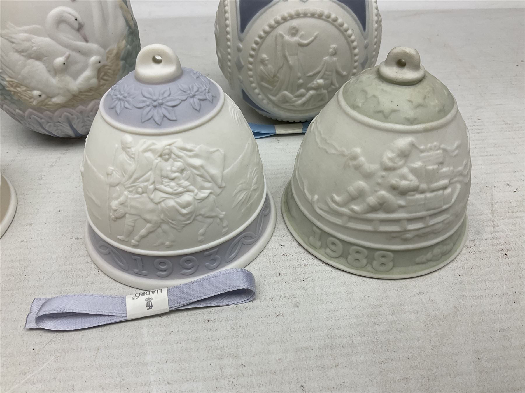 Seven Lladro bells, comprising Summer no 17614, Fall 17615, Christmas 1988 no 5525, Christmas 1989 no 5616,  Christmas 1990 no 5641, Christmas 1992 no 15913 and Christmas 1993 no 16010, together with two Lladro Christmas balls no 1603 and Lladro easter eggs 1994 no 17532