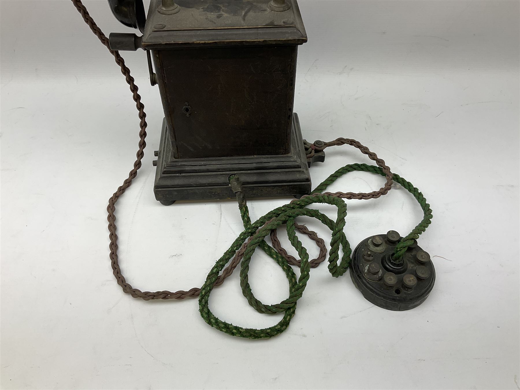 Early 20th century Danish desk telephone inscribed The Ericsson Bell Telephone Co. Glasgow to one side and Aktieselskabet Electrisk Bureau Kristiansand to the other, ebonised wooden top with handset on brass cradle. black japanned tin centre section bearing Hull Corporation Telephones Department crest, side cranking handle and ebonised wooden base H30cm  