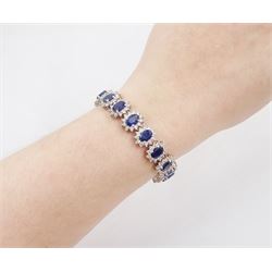 18ct white gold sapphire and diamond bracelet, nineteen clusters each set with a single oval cut sapphire and round brilliant cut diamond surround, stamped 750, total sapphire weight 18.20 carat, total diamond weight 6.38 carat