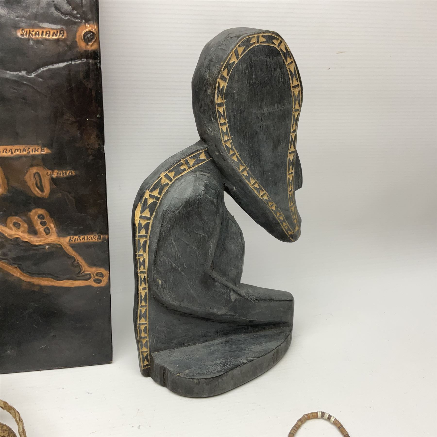 Collection of traditional necklaces from the Solomon Islands, including shell and boar tusk examples, together with a carved canoe prow, with mother of pearl eyes, painted cow hide and a copper plaque, depicting the Solomon Islands, with presentation engraving