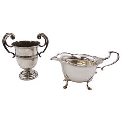 Early 20th century silver sauce boat, of typical form, with shaped rim and scroll handle, upon four hoot feet, hallmarked Henry Williamson Ltd, Birmingham 1915, together with a small 1930's silver trophy, with girdle and twin flying scroll handles, upon a stepped circular foot, hallmarked John Henry Potter, Sheffield 1933, approximate total weight 9.82 ozt (305.4 grams)