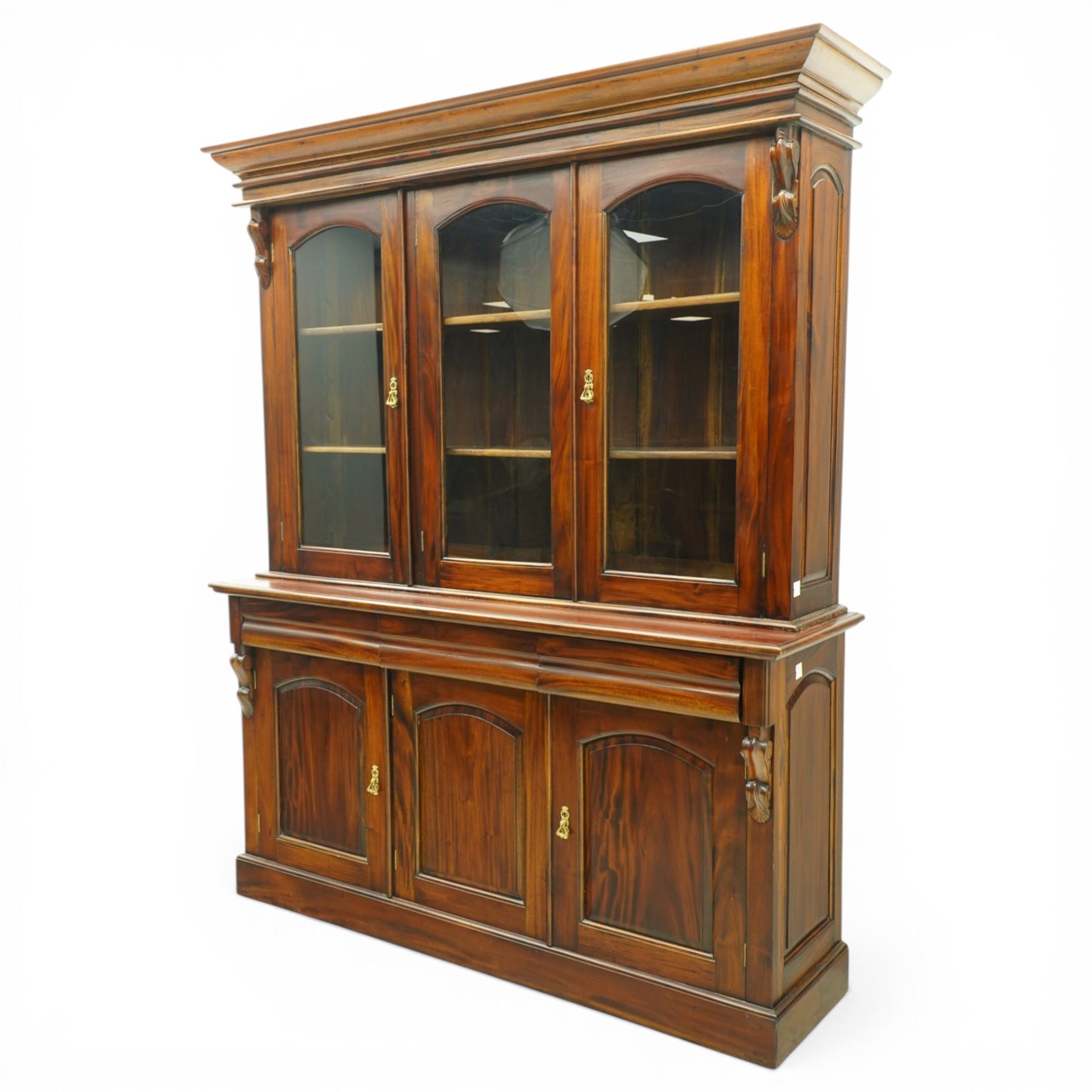 Victorian revival hardwood dresser cabinet, projecting moulded cornice above three glazed doors with shaped tops enclosing shelves, moulded top over three drawers and three panelled cupboard doors, flanked by applied carved brackets, on plinth base