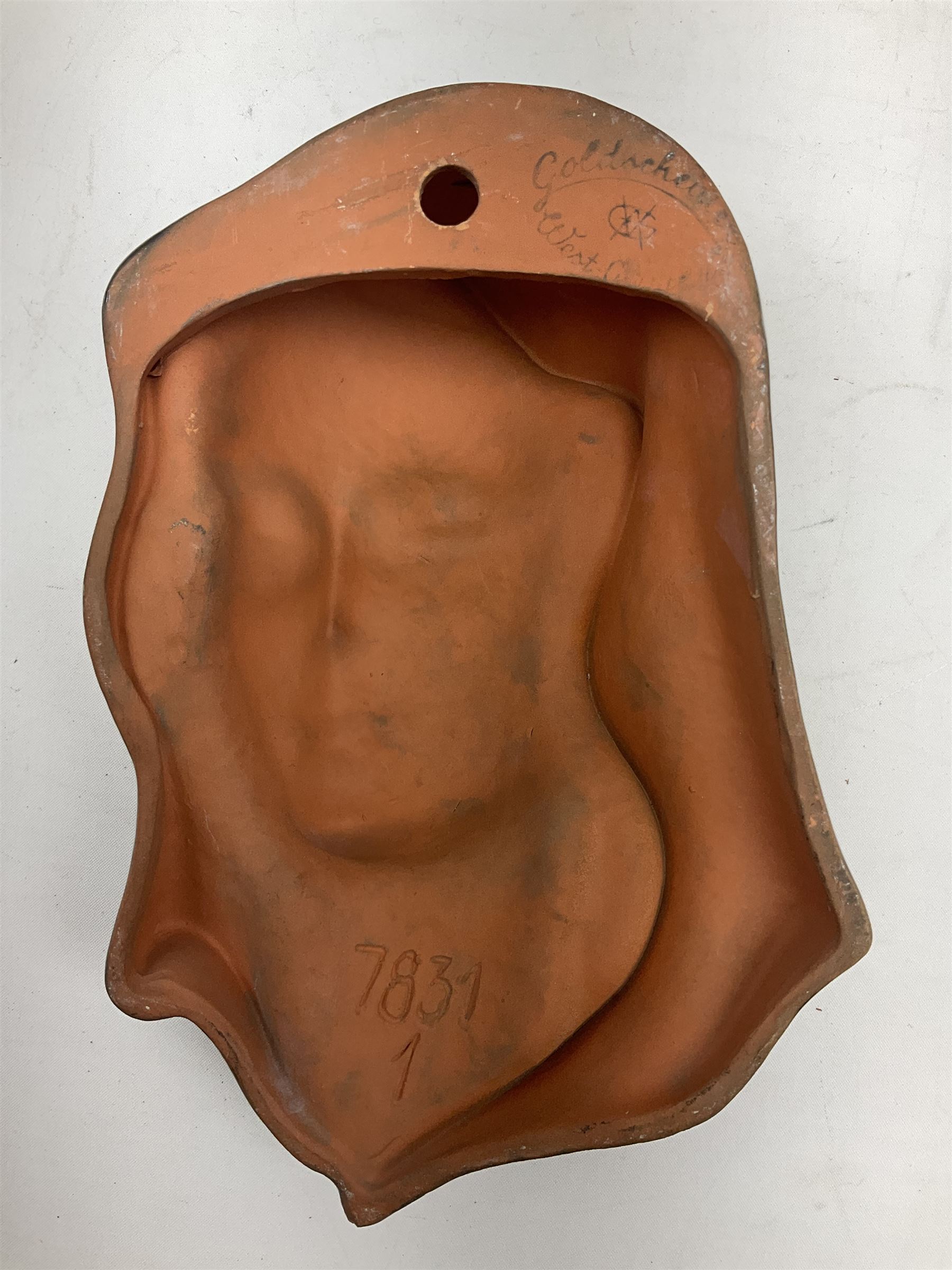 Art Deco Goldscheider terracotta wall mask, modelled as a woman in a black headscarf, model no 7831, with printed mark to back, H20cm 