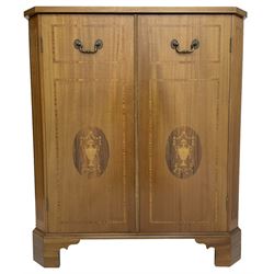 John More of Scarborough -  Edwardian Revival 'Canterbury Cabinet' inlaid mahogany cabinet, fitted with double cupboard decorated with urn motif inlays and banding, flanked by canted fluted uprights, on bracket feet