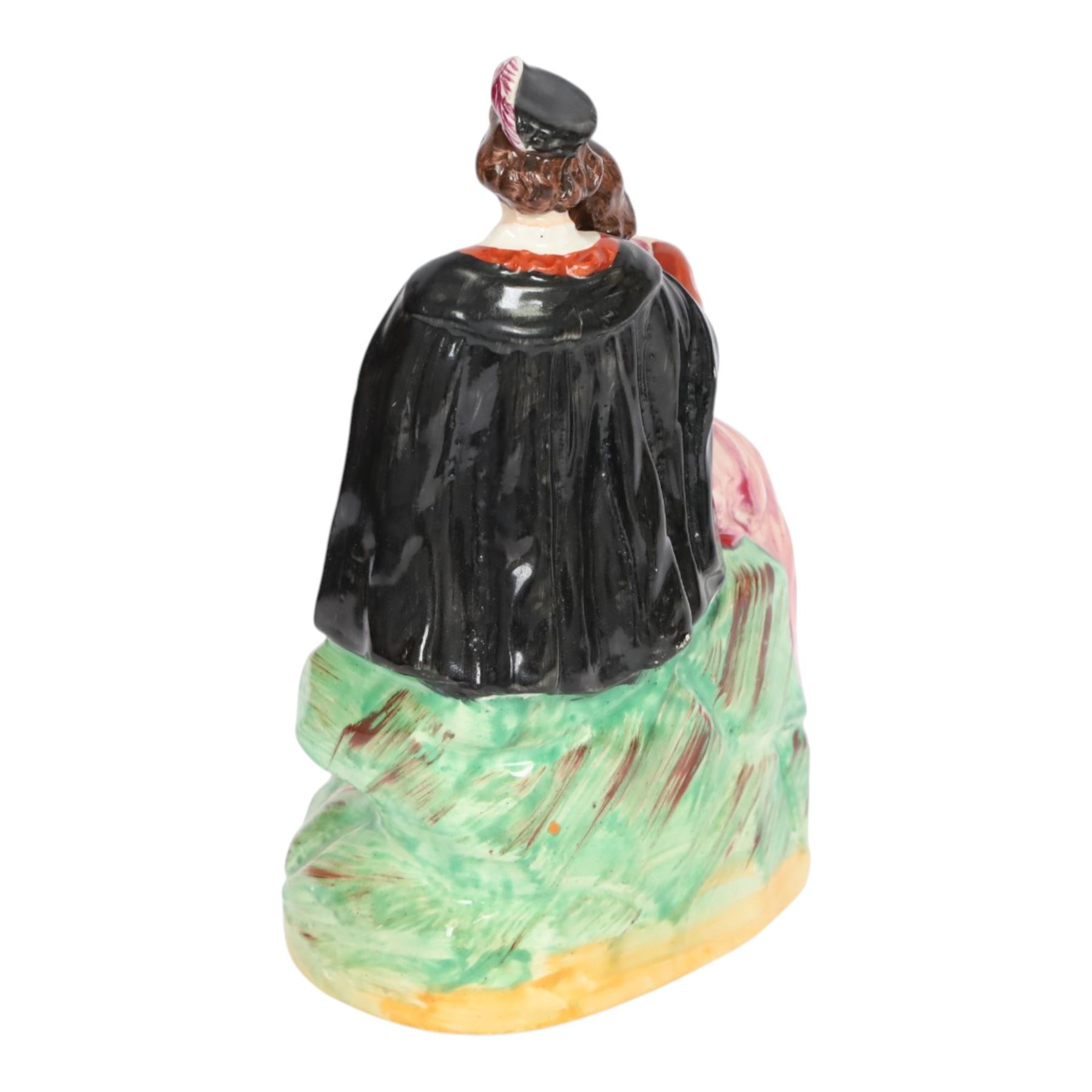 Rare Staffordshire pottery figure group, circa 1852, modelled as Romeo and Juliet, both seated upon a naturalistic base with their arms around one another, Romeo wearing cloak and plumed hat, Juliet in long dress, H20cm