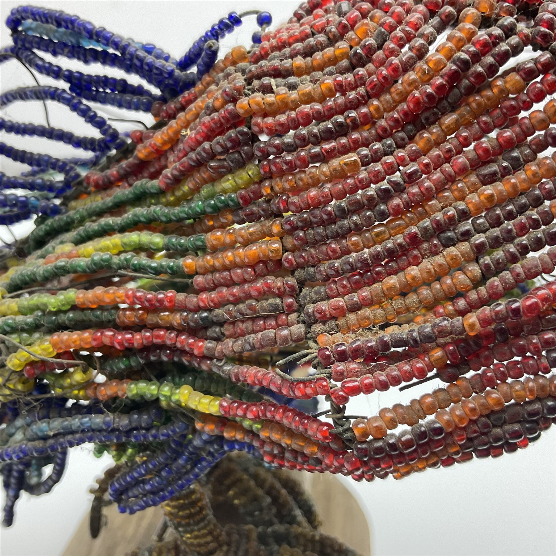 Victorian bead and wire model of a parrot, of polychrome beads, with glass eyes, on a wooden base, H24cm
