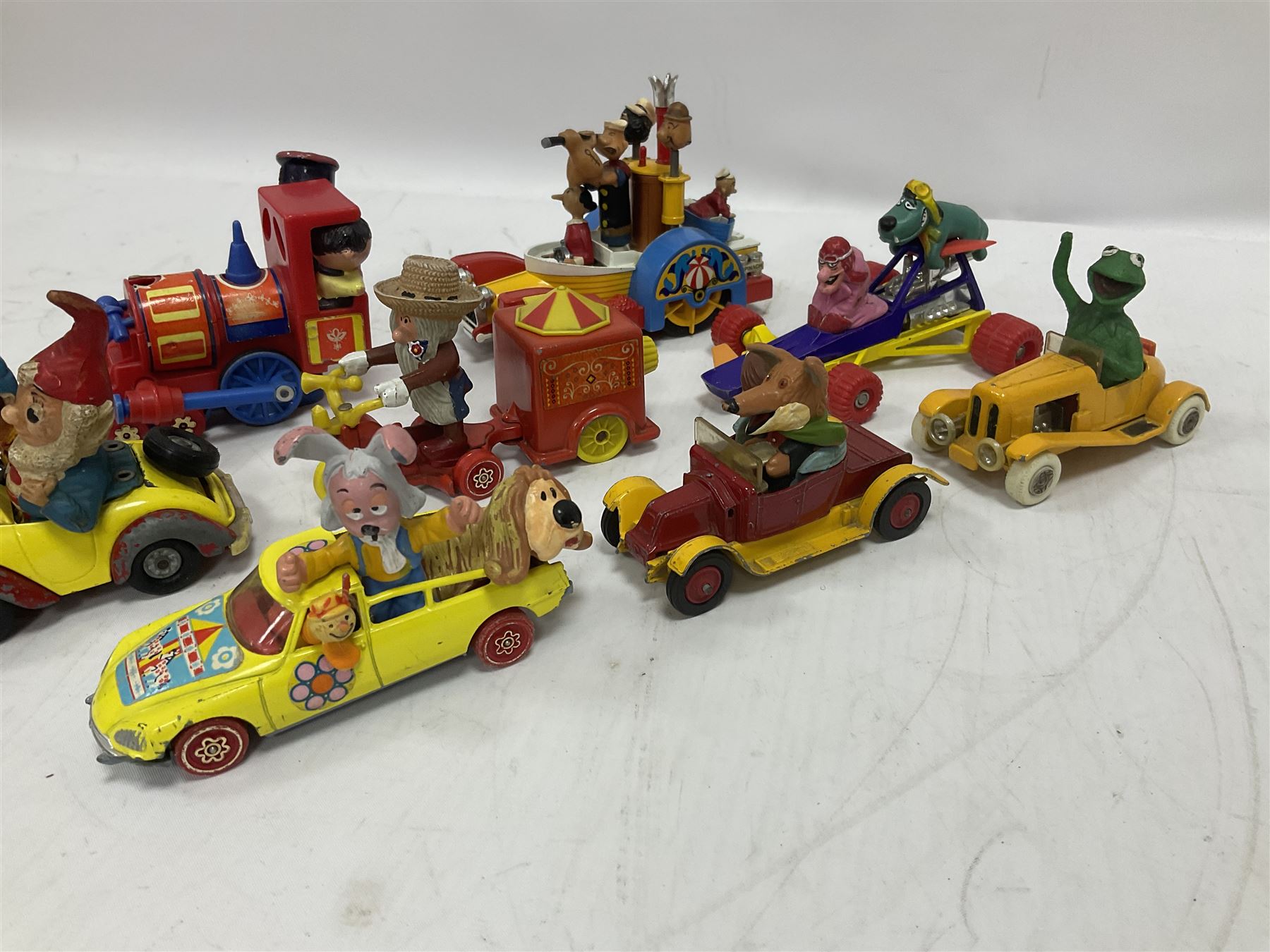 Corgi/Dinky - twelve unboxed and playworn TV/Film related die-cast models including Popeye Paddle Wagon; Dick Dastardly; Magic Roundabout; Muppets; Basil Brush; and Noddy (12)