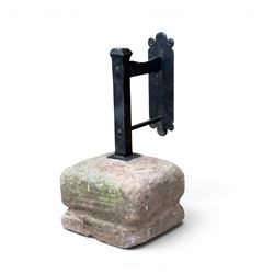 Large wrought metal boot scraper in black painted finish, set in formed stone plinth