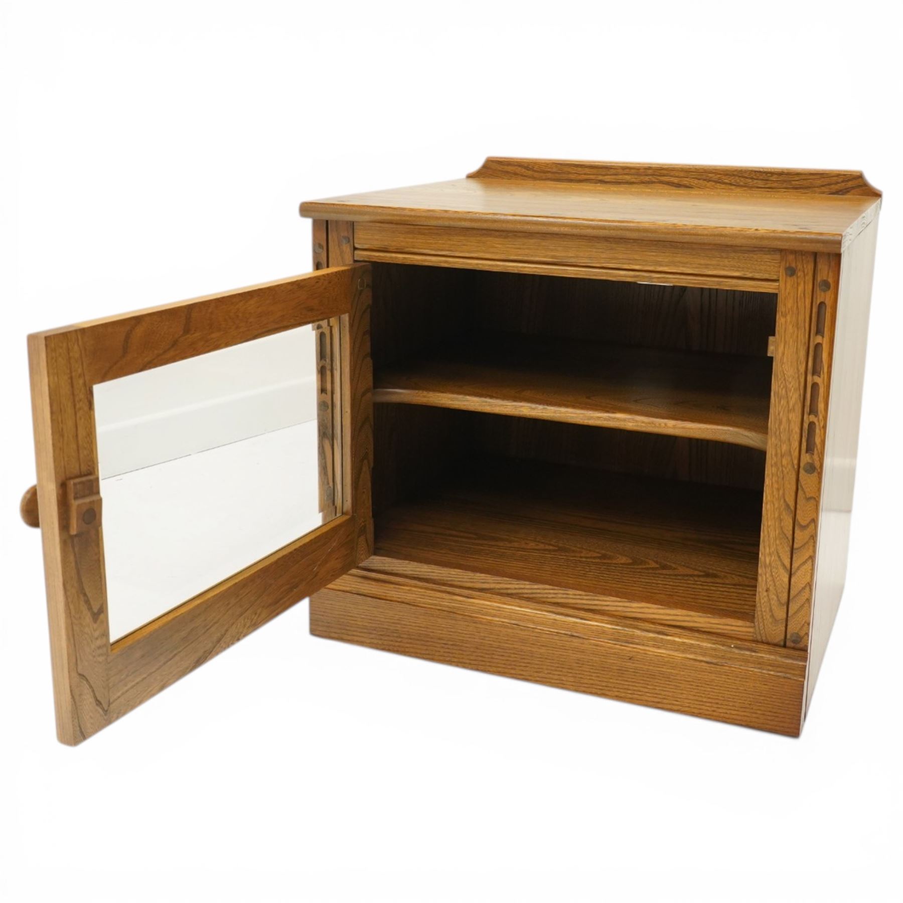 Ercol - elm media cabinet of small proportions, fitted with glazed door enclosing single shelf, on skirted base