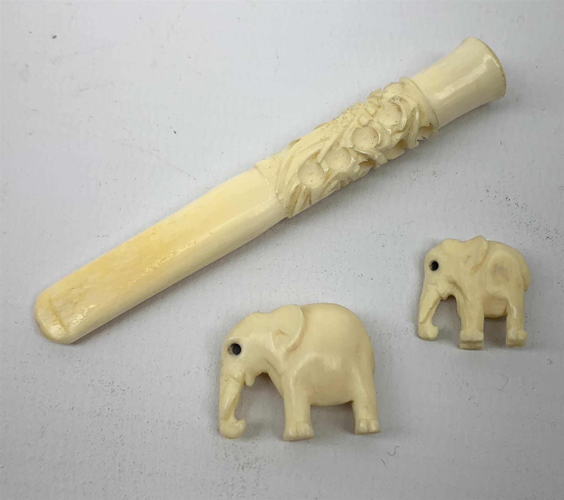 A Japanese ivory netsky modelled as a chick hatching from an egg, with marks beneath, together with a further netsky modelled as a seated chicken, also marked, a carved ivory cheroot holder, and two small carved ivory elephants, plus a Japanese stand modelled in the form of a crane, with character marks to base, a Japanese bamboo detailed teapot, cloisonne circular  pot, and an embroidered pouch and purse. 