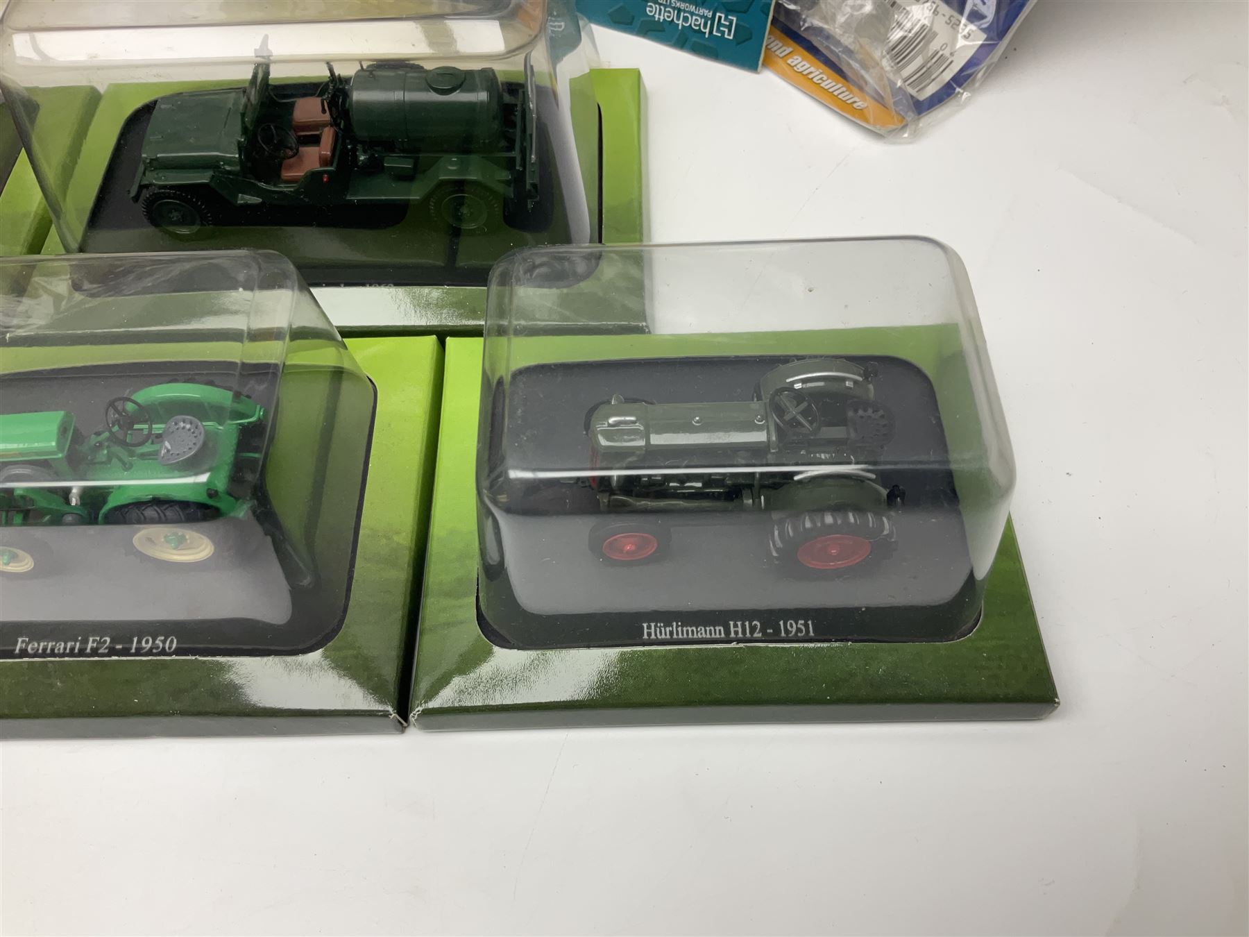 Eighteen issues of Tractors and The World of Farming magazine, together with sixty diecast tractors, all in original packaging, in three boxes 