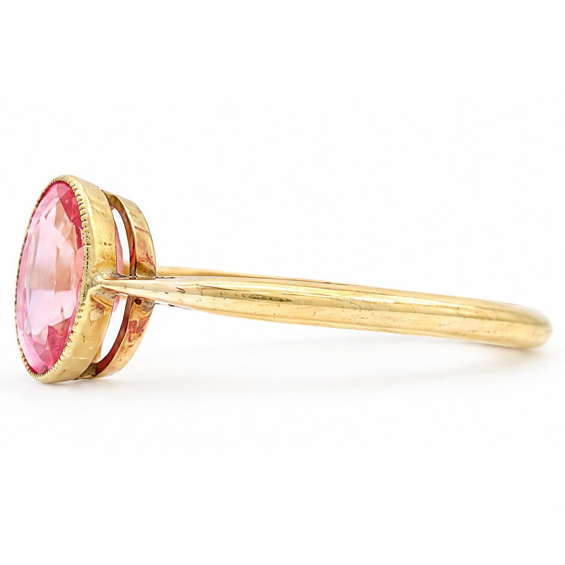 Early 20th century gold padparadscha sapphire ring, milgrain set with a single oval cut sapphire of approx 1.05 carat