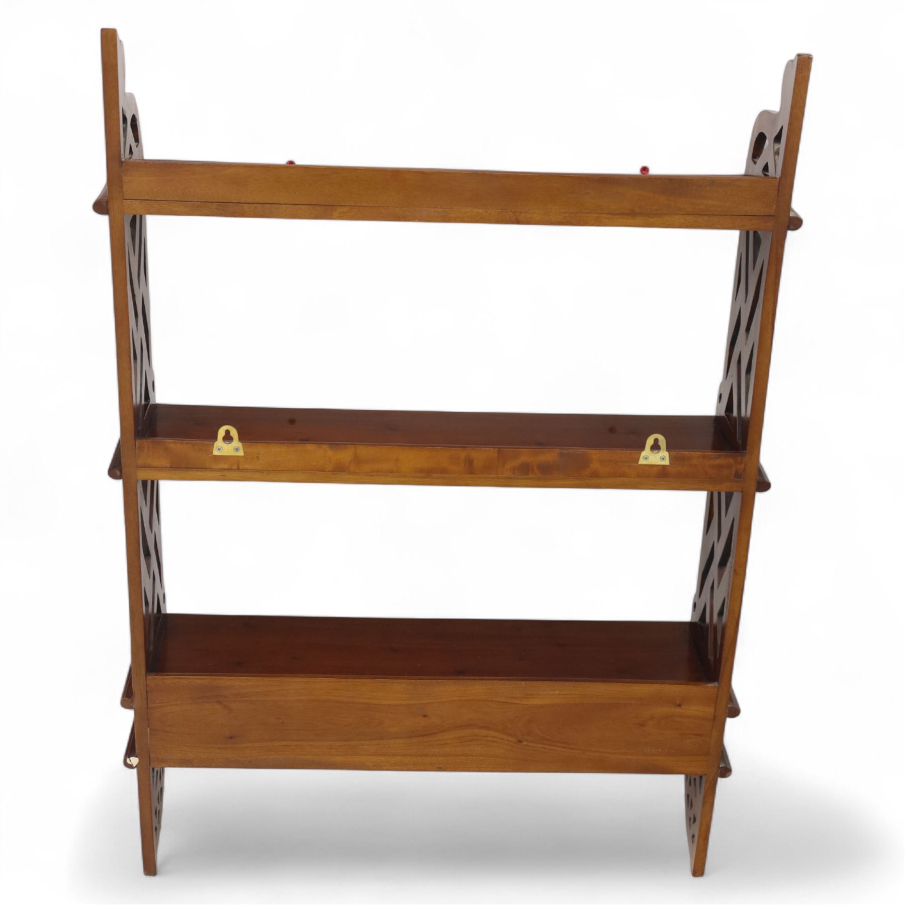 Two mahogany wall hanging items, comprising a French mahogany overmantel mirror with reeded uprights and moulded cornice (H 68cm, W 97cm, D 10cm), together with a mahogany wall shelf unit with three tiers and fretwork sides, the lower section fitted with three small drawers (H 95cm, W 63cm, D 18cm) (2)