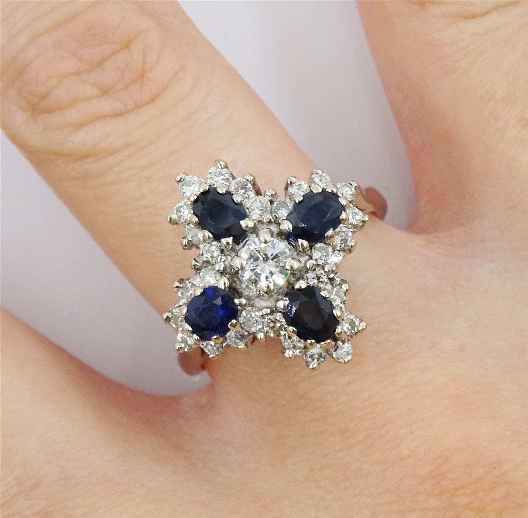 White gold oval sapphire and round brilliant cut diamond cluster ring