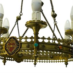 Gothic Revival brass six-light ecclesiastical chandelier, circular frame with pierced trefoil cresting and apron, applied with polychrome Sacred Heart medallions, six candle-form electric sconces, suspended on twisted brass rods and chains from a coronet-form ceiling boss