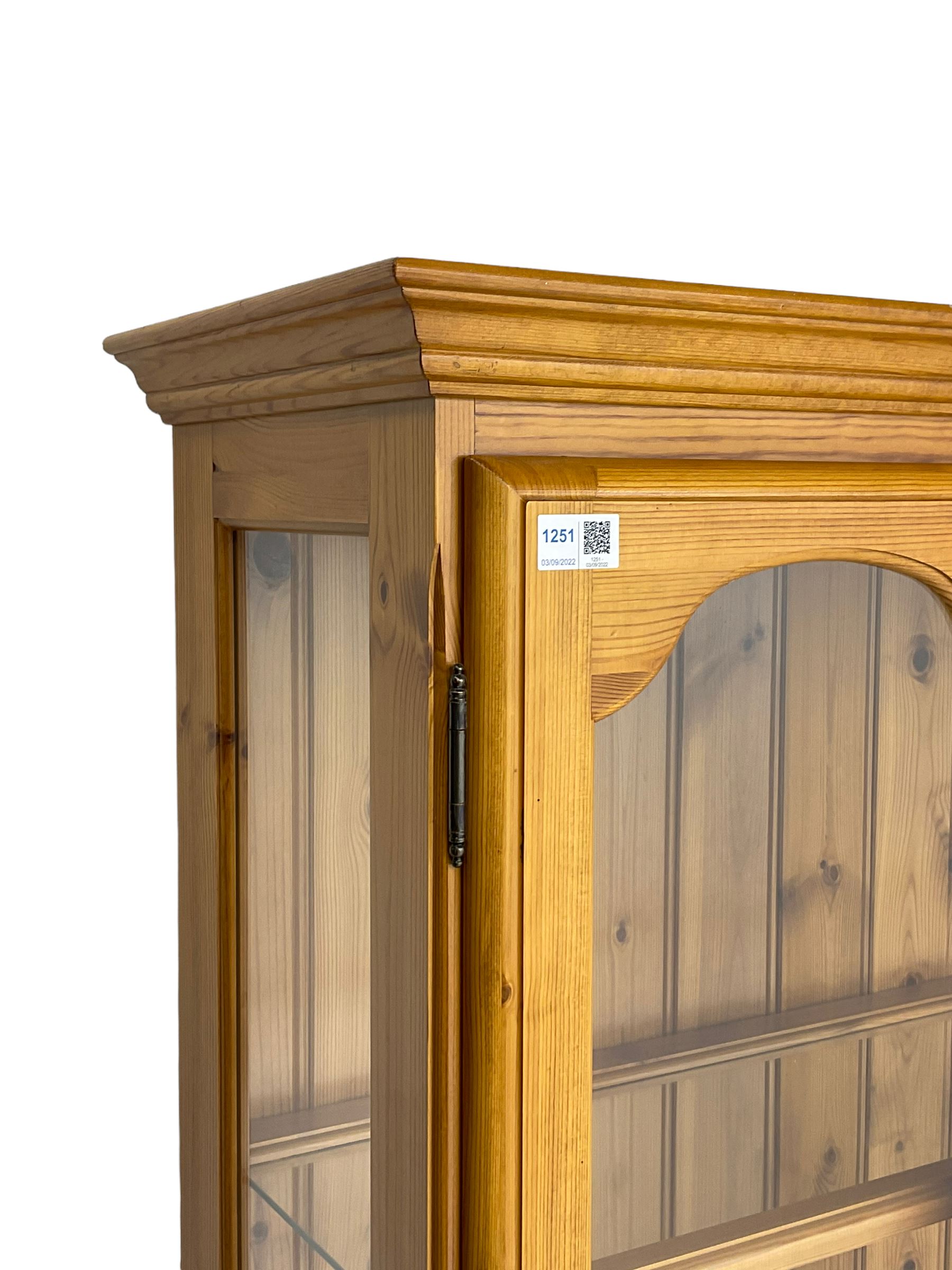 Pine display enclosed by glazed doors, fitted with three