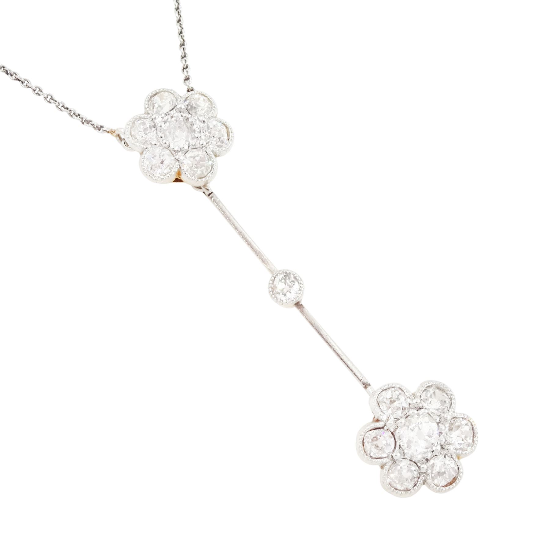Early 20th century 18ct gold and platinum, milgrain set, old cut diamond double flower head cluster pendant necklace, total diamond weight approx 1.20 carat