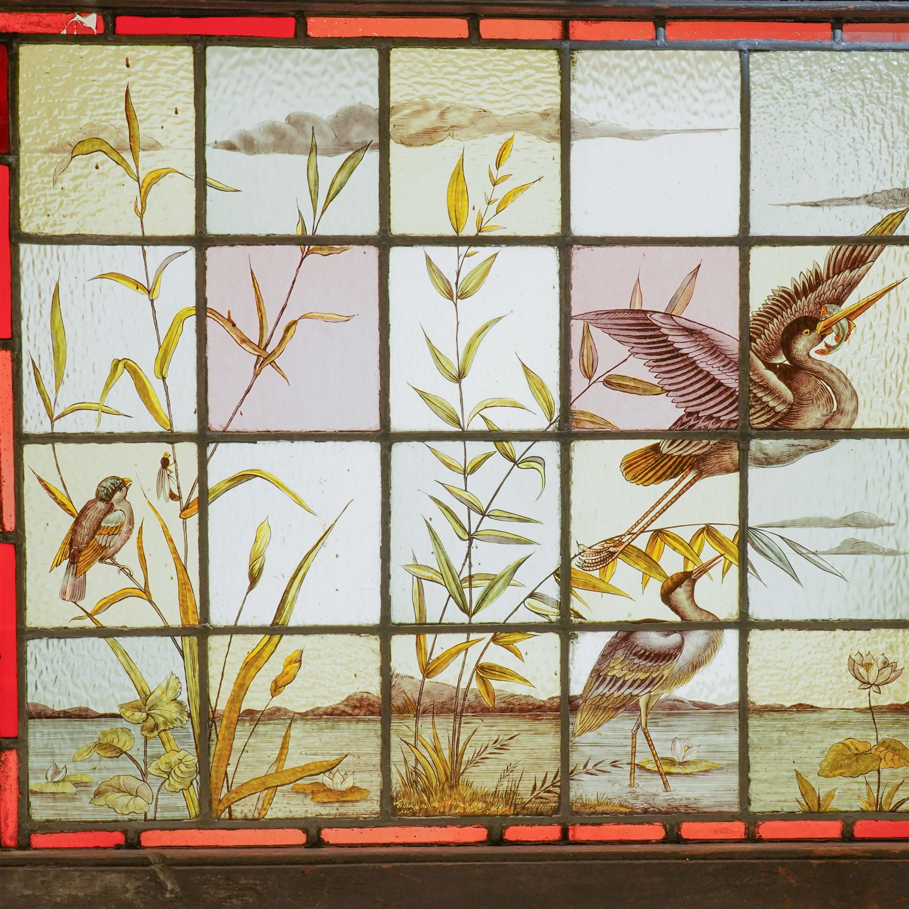Large Victorian Aesthetic movement stained glass leadlight window panel, hand painted with a scene of herons and other birds in a lake, overall 82cm x 147cm 