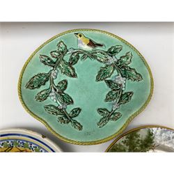 Majolica plate decorated with yellow and brown bird upon fruiting holly branches on teal ground with mustard rope twist border, together with two other plates to include a Faience style example, D27cm