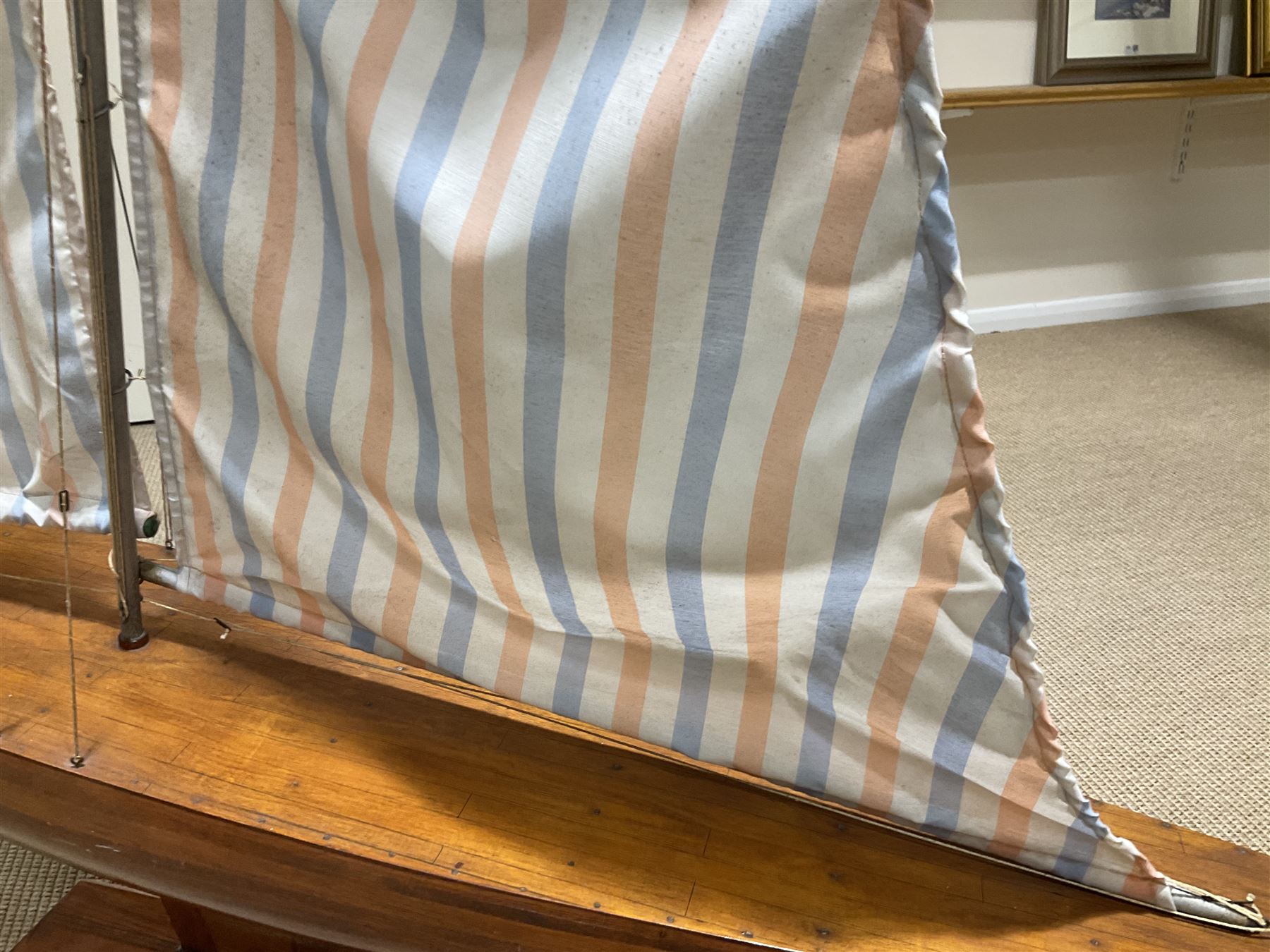 Large pond yacht with simulated planked mahogany deck, mahogany hull, wooden keel and stern fin and tubular aluminium mast with two sails; on wooden stand L131cm H on stand 177cm