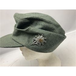 WW2 German Army M43 field cap with triangular cloth eagle and roundel badge and metal edelweiss badge for mountain troops; faintly stamped '5 VMF(?)'