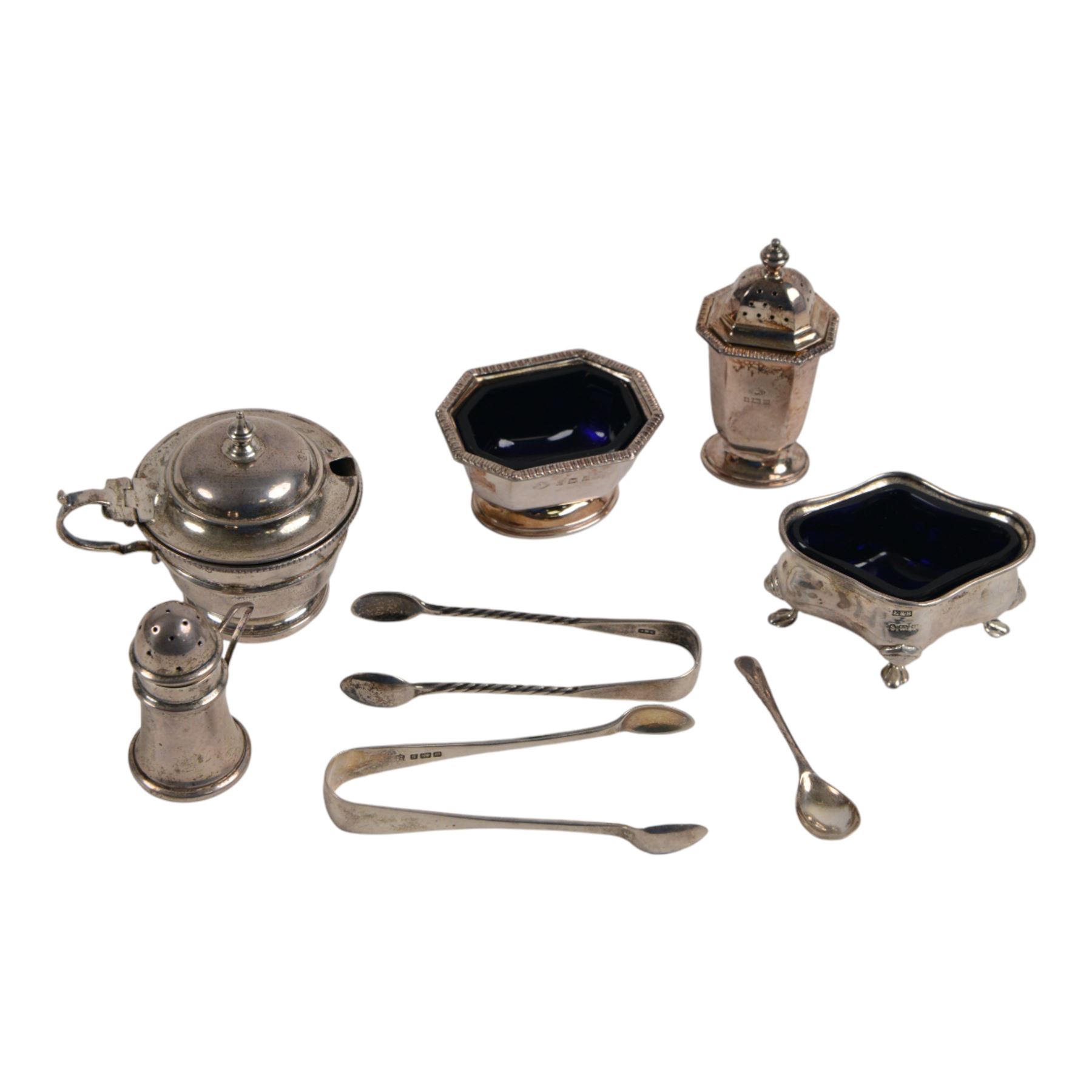 Collection of silver cruet items and flatware, including miniature muffineer, two pairs of sugar tongs, mustard pot and cover, open salts and pepper shaker, all hallmarked