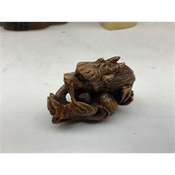 Hardwood bust of an Indoniesian Goddess, carved wearing a pierced headdress, from Klungkung, Bali, H20cm, together with a pair of bone carvings of deity figures, and a carved wood Netsuke in the form of a Chinese dragon