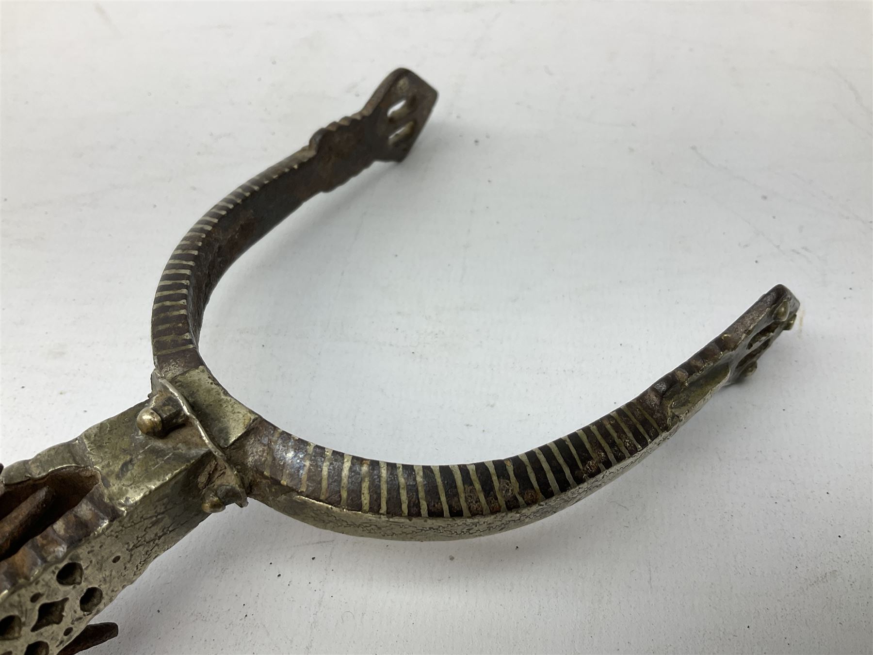 Pair of late 19th century South American iron spurs, engraved silver mounts, with sunburst rowls