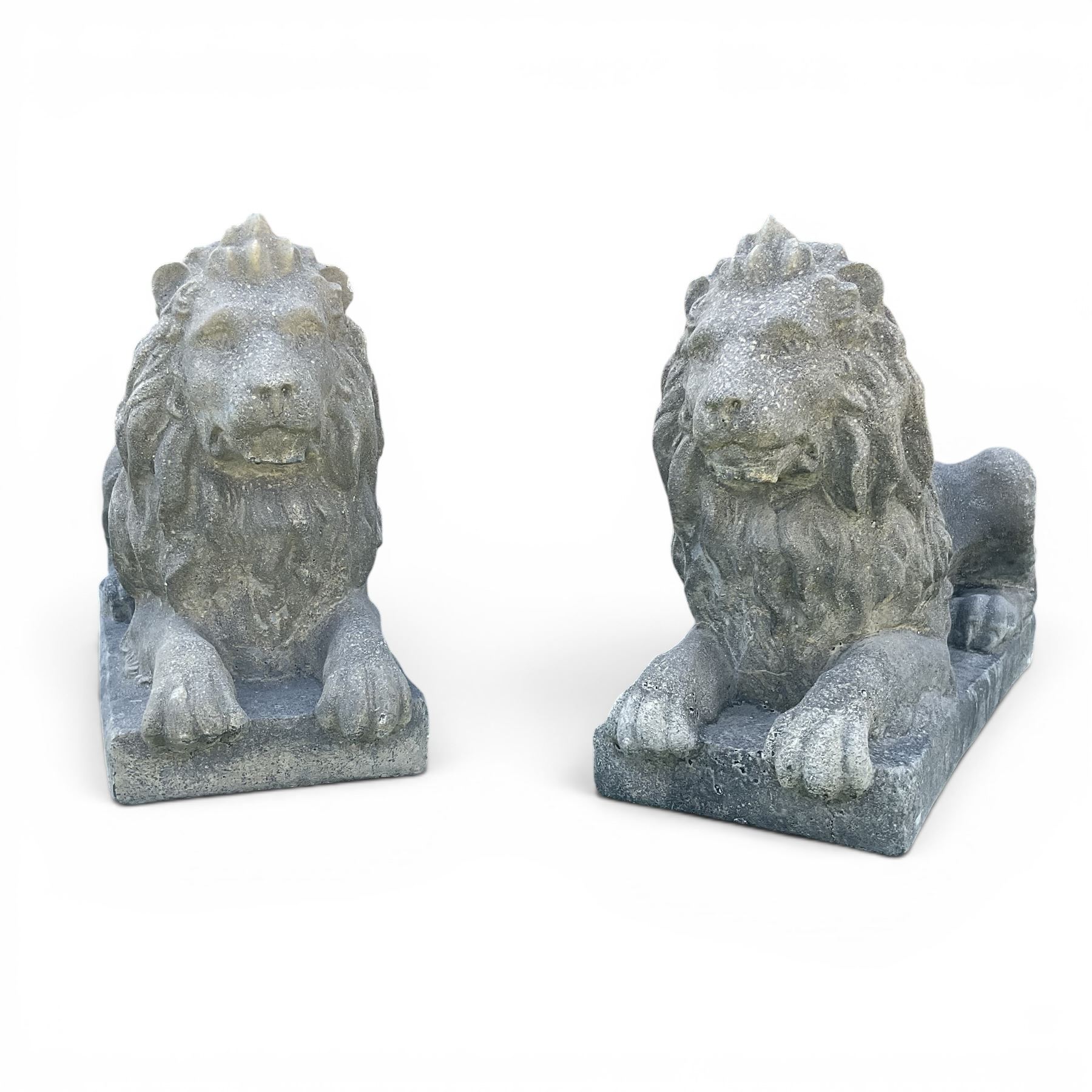 Pair of large cast stone recumbent garden male lions, modelled with flowing manes and raised heads with closed jaws, on rectangular plinth bases