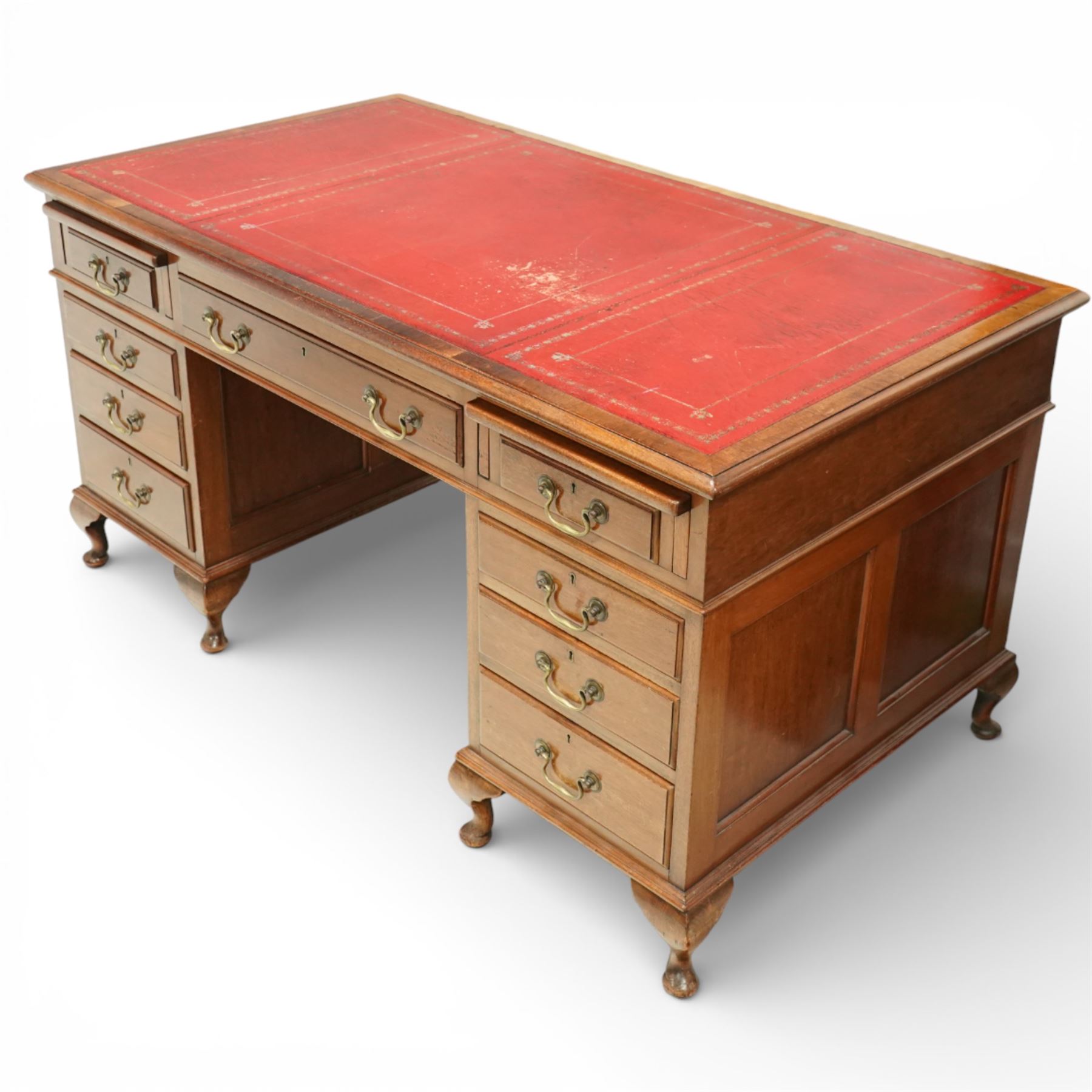 Late 19th century mahogany pedestal desk, rectangular top inset with worn red leather writing surface with gilt tooling, three frieze drawers above opposing pedestals each fitted with four graduated drawers, brass swan neck handles and escutcheons, panelled sides and back, raised on turned feet