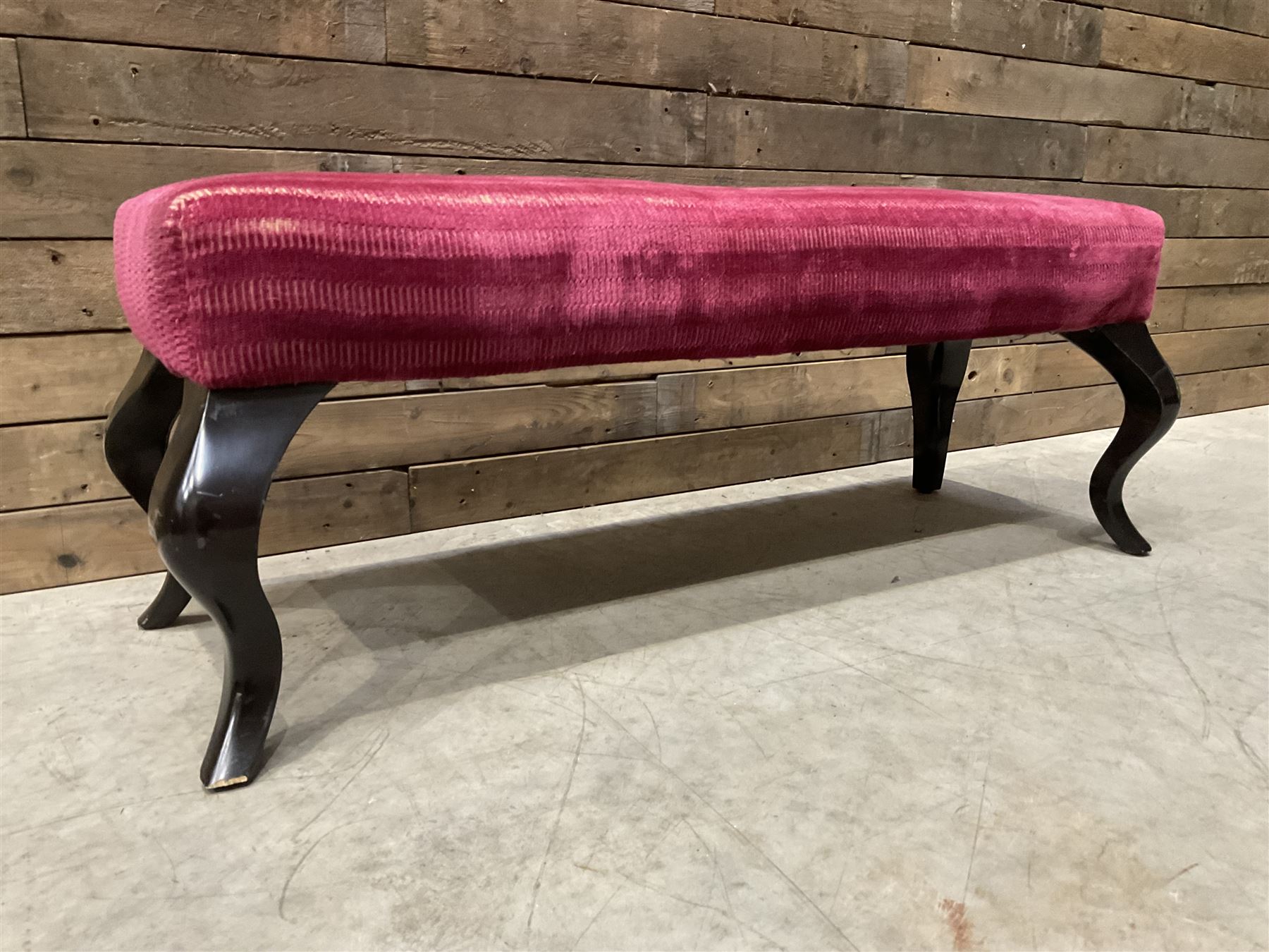 Large rectangular footstool upholstered in a maroon fabric with cabriole supports