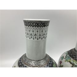 Pair of Chinese Republic porcelain vases, each painted in Famille Rose enamels with pairs of pigeons amidst peony, rock, flowering plants and leafy branches, possibly Qianlong seal beneath, H22cm 