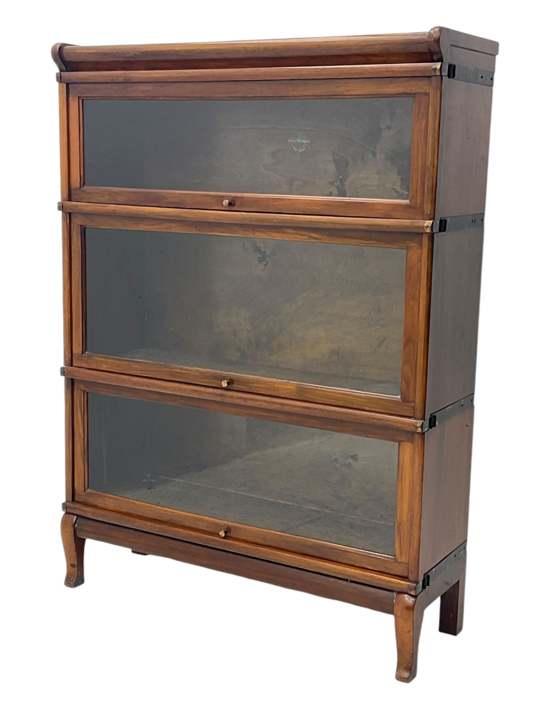 Globe Wernicke - early 20th century mahogany three-tier stacking library bookcase, three glazed sections enclosed by hinged and sliding doors, interior with transfer label, raised on cabriole front supports