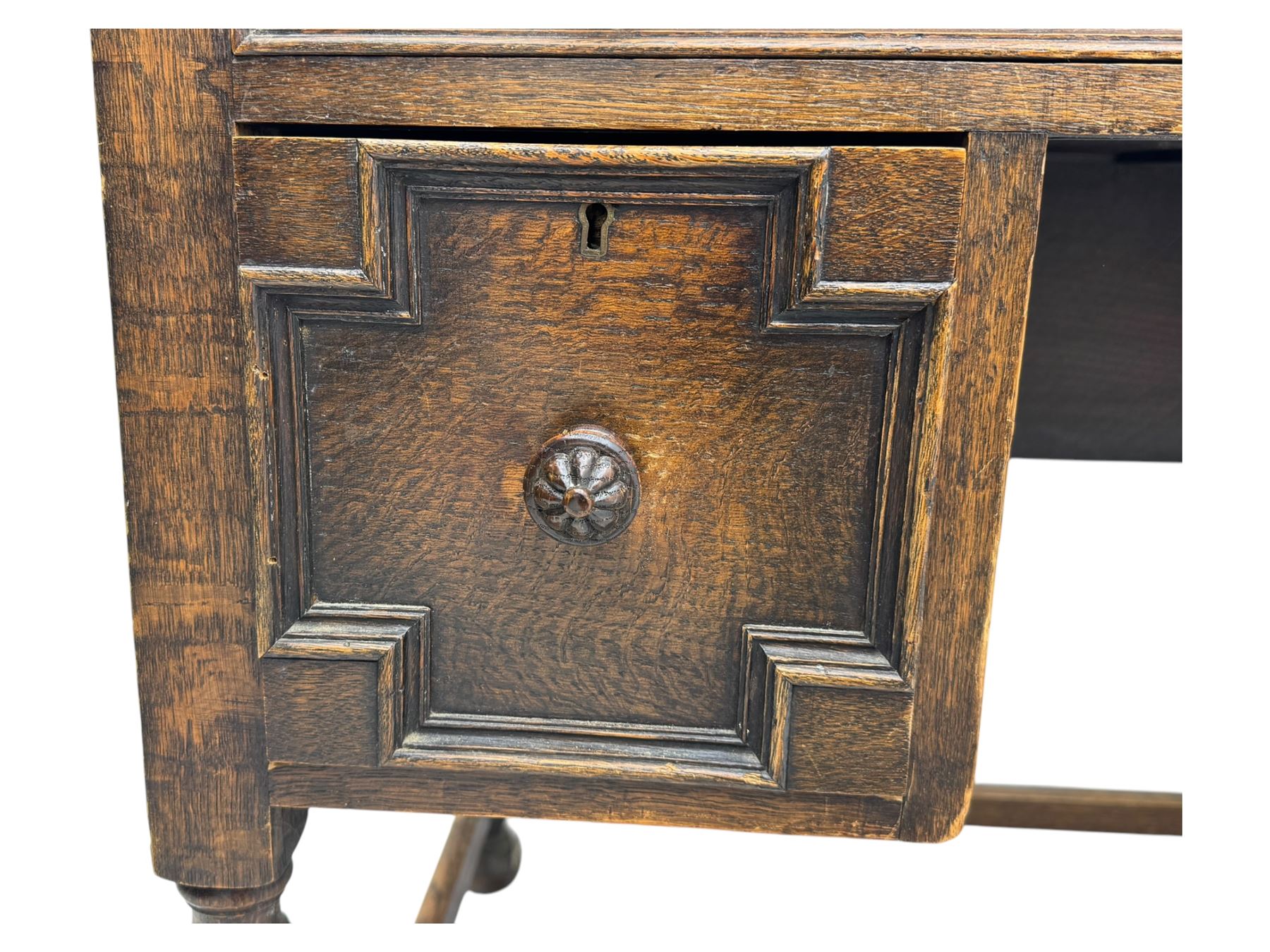 Early 20th century Jacobean design oak desk, with rectangular top inset with worn tooled leather, two frieze drawers over pedestals each fitted with a pair of panelled drawers, turned handles, on carved and fluted tapering legs united by stretchers 