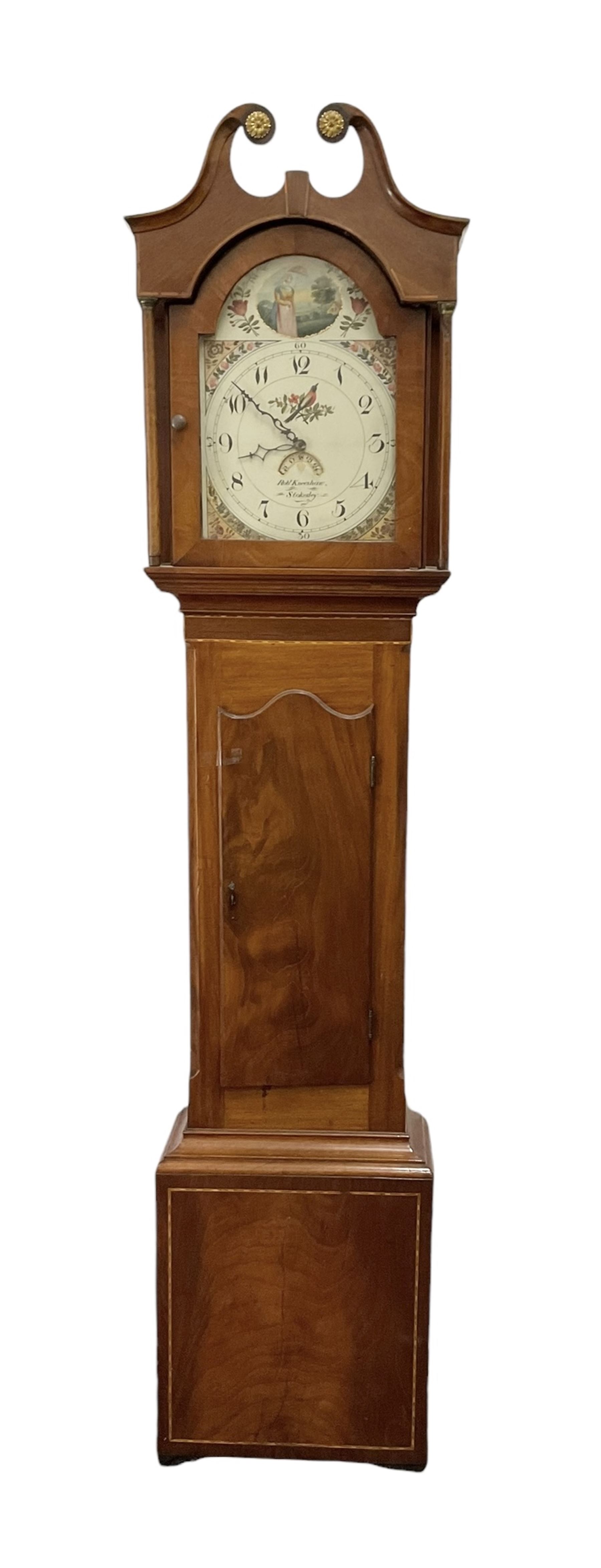 Robert Kneeshaw of Stokesley - 19th century 30 hour mahogany cased longcase clock c1820. with a swans necked pediment and brass paterie, break arch hood door with plain pilasters, inlaid trunk with canted corners, inlay and a wavy topped door, on a rectangular plinth with a shaped base, painted dial with floral spandrels and a depiction of a lady walking in the countryside, with Arabic numerals, non-matching steel hands, calendar aperture and an image of a bird of paradise to the centre, chain driven countwheel striking movement, with weight and pendulum.  