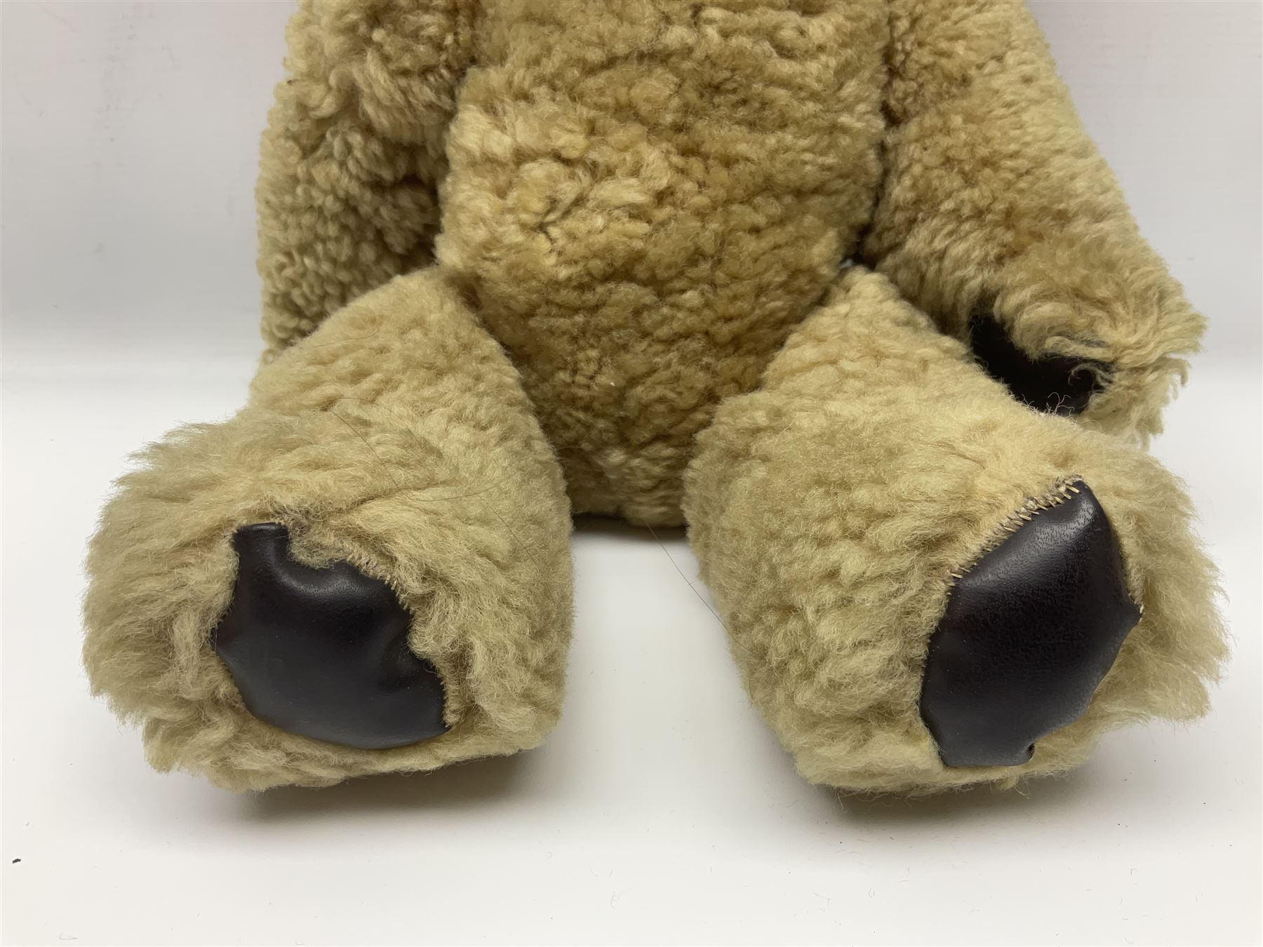 1950s sheepskin plush covered teddy bear with musical movement, the revolving head with applied eyes, leather nose and stitched mouth, jointed limbs with leather pads H50cm