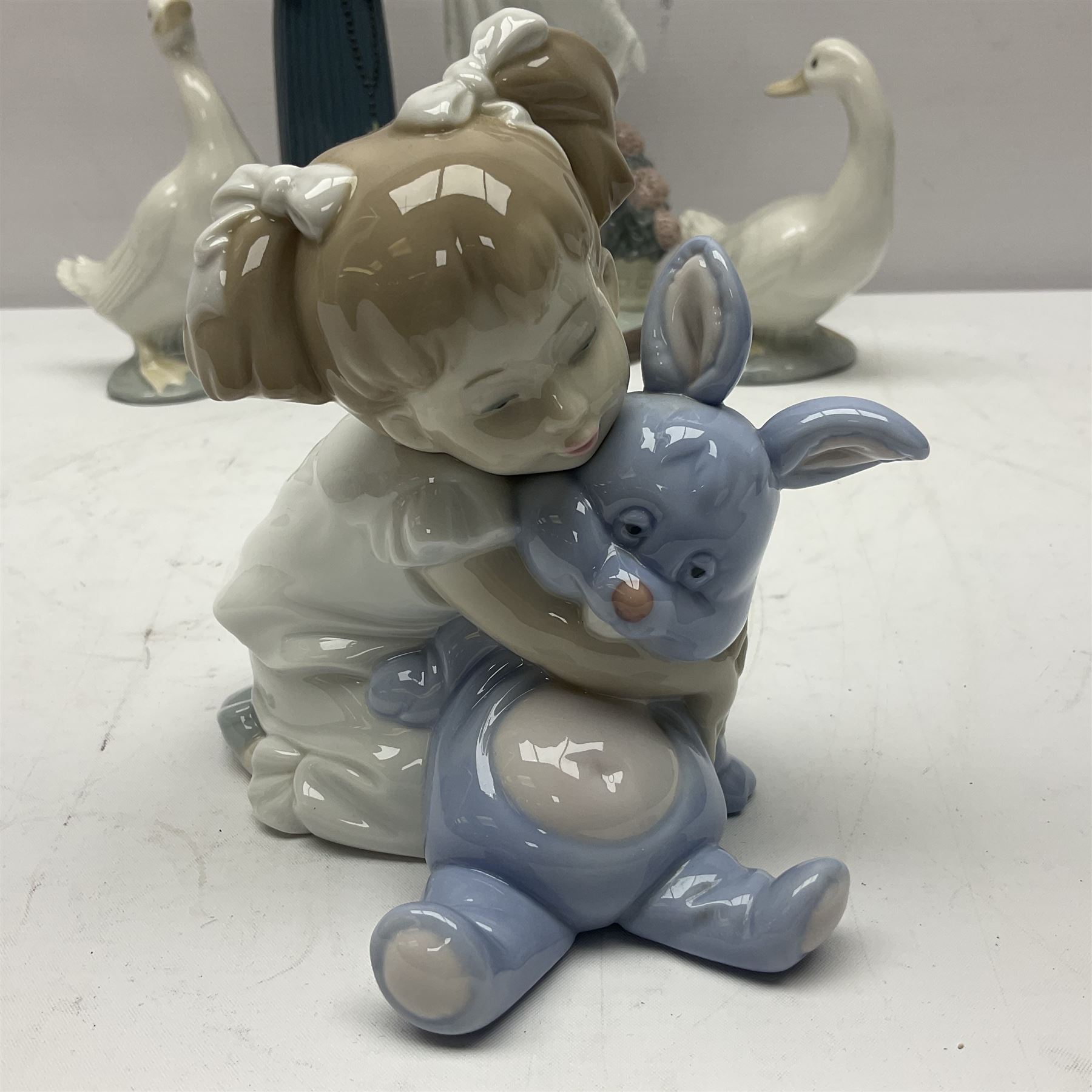 Two Lladro figures, Over the Threshold no 5282 and Prayful Moment no 5500 together with five Nao figures