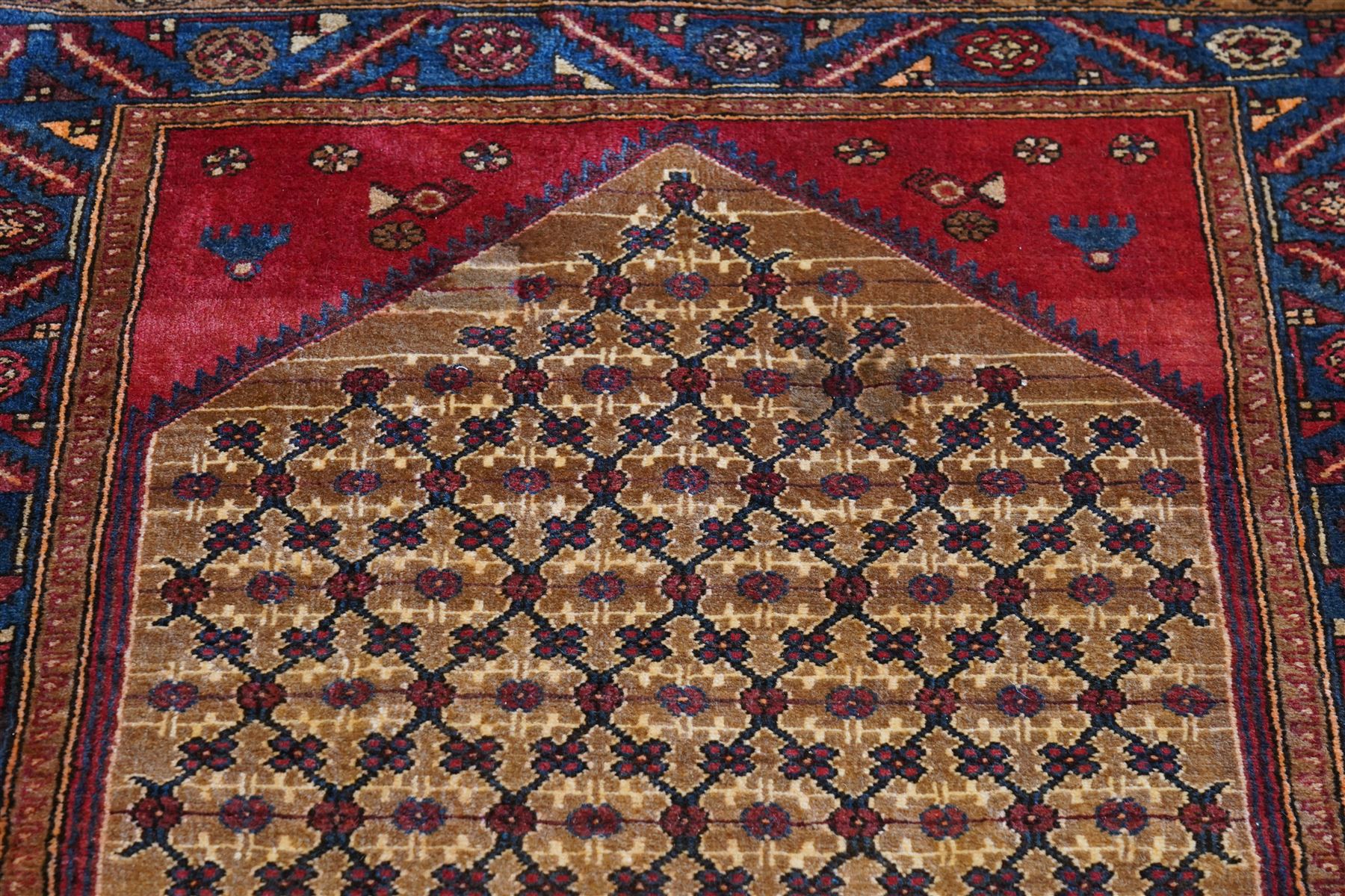 North East Persian Kurdie hand-knotted runner, camel ground with an all-over lattice of rosette motifs linked by angular vines, terminating in a stepped lozenge panel, with a madder red field, spandrels with geometric and zoomorphic devices, indigo main border of angular vines and repeating rosettes, flanked by narrow guard stripes, cotton fringe ends  
