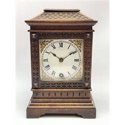Early 20th century walnut cased mantel timepiece clock, sloping top over glazed door with carved frame, silvered Roman dial with ornate gilt metal spandrels, single train driven movement, the movement back plate stamped 'Lenzkirch'