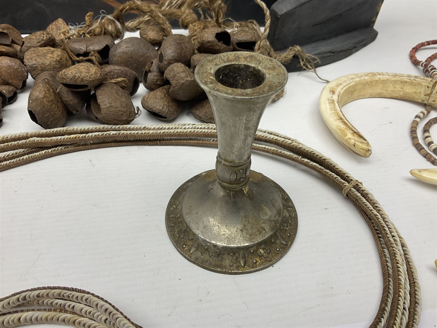 Collection of traditional necklaces from the Solomon Islands, including shell and boar tusk examples, together with a carved canoe prow, with mother of pearl eyes, painted cow hide and a copper plaque, depicting the Solomon Islands, with presentation engraving