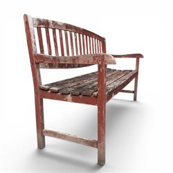 Teak garden bench, with slatted seat and spindle back, shaped armrests, finished in weathered red painted finish.