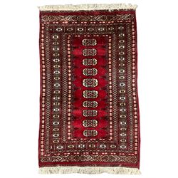 Persian Bokhara rug, red ground and decorated with single row of Gul motifs, multiple band border with geometric design