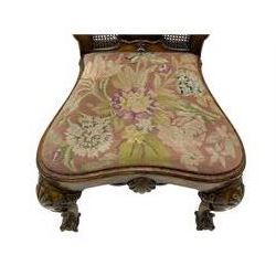 Pair of early 20th century Queen Anne design chairs, the cresting rail carved with scroll and central shell motif, shaped uprights and splat encased in cane work panels, shaped moulded seat frame with shell motif, floral needlework upholstered drop-in seat cushion, on shell carved cabriole supports with ball and claw feet, united by turned and shaped middle stretcher carved with acanthus leaf