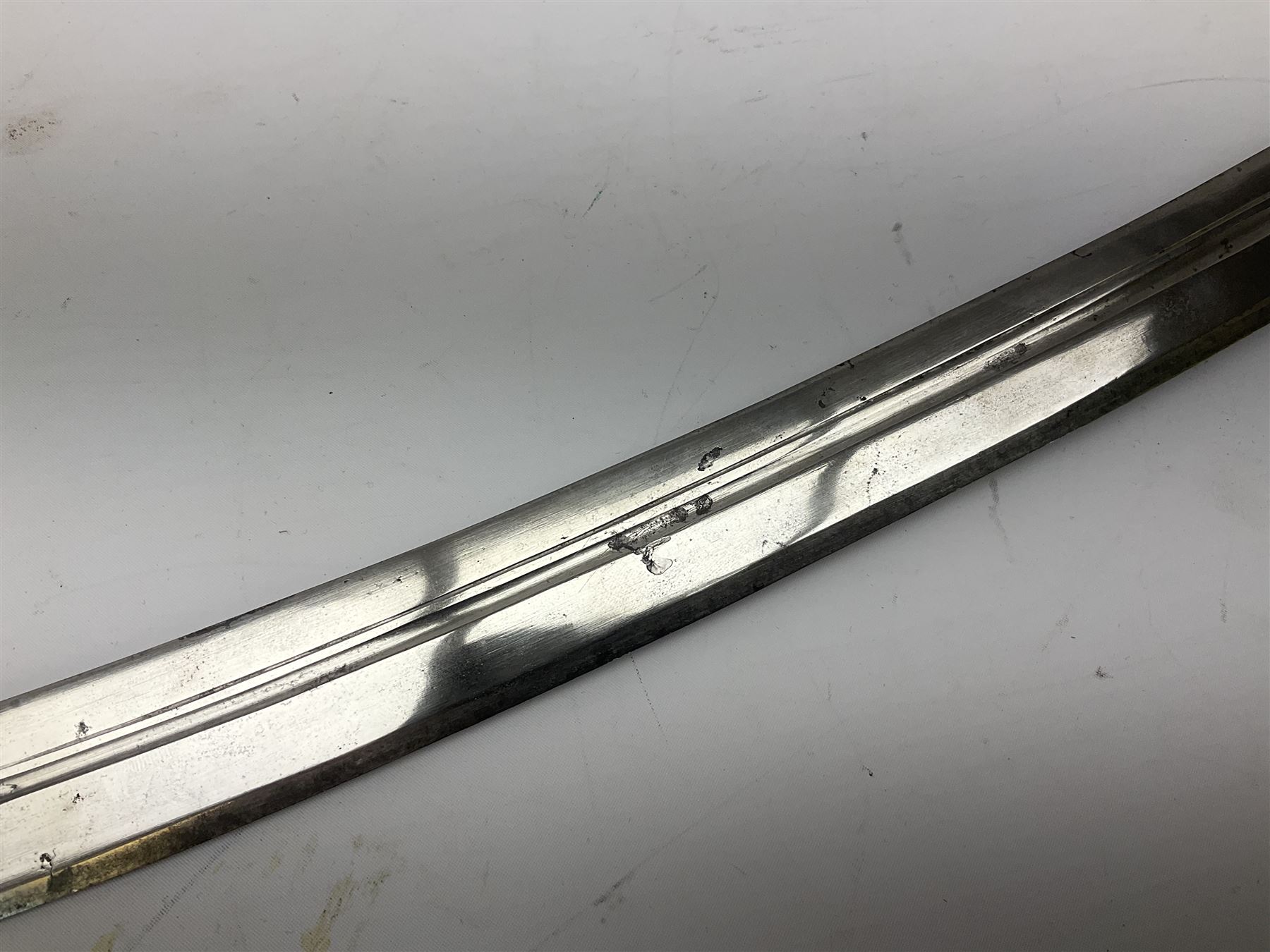 19th Century Indian Tulwar sword with 77cm single edged, slightly curved fullered blade;  steel crossguard, langets, grip and spiked disc pommel with stiff leaf decoration L90cm overall